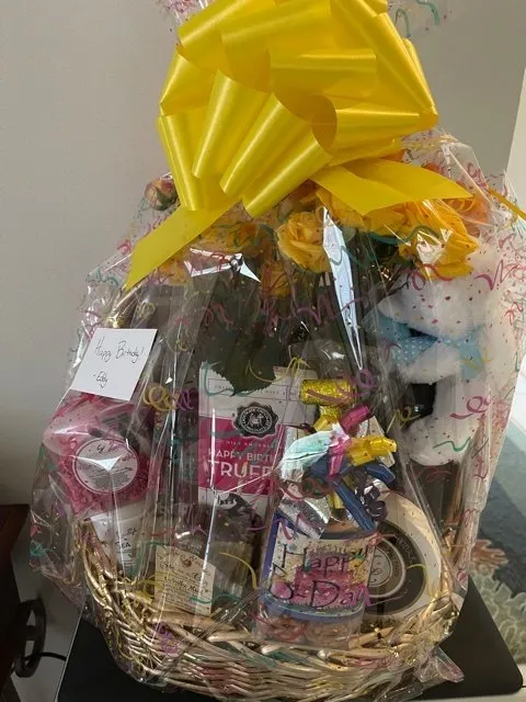 Birthday gift basket with treats, ribbon.