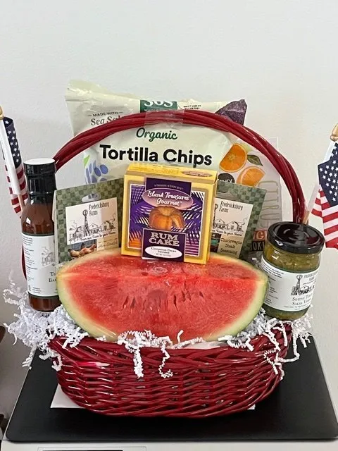 Basket with chips, watermelon, salsa, cake.